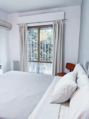 a bedroom with a white bed and a window at Gran Lourdes Hotel in Villa Carlos Paz