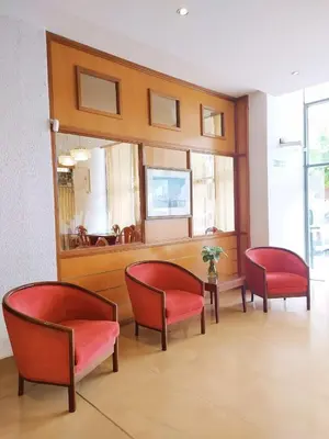 a waiting room with red chairs and a mirror at Gran Lourdes Hotel in Villa Carlos Paz