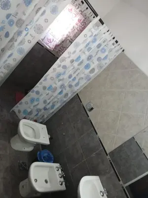 a bathroom with two urinals and a window at santa rita 2 in Cordoba