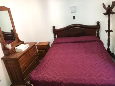 a bedroom with a bed and a dresser and a mirror at santa rita 2 in Cordoba