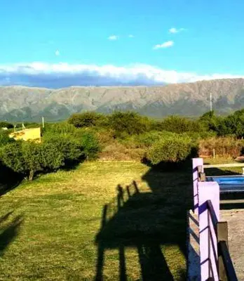a shadow of a fence on a field with mountains at Flor silvestre in Carpintería