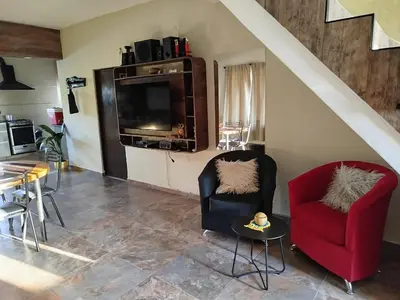 a living room with two chairs and a television at Flor silvestre in Carpintería