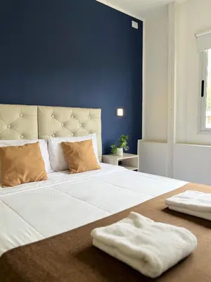 a large white bed with two towels on it at Astoria Hotel in Villa Carlos Paz