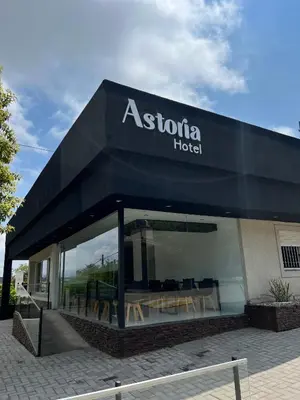 a restaurant with a sign on the side of a building at Astoria Hotel in Villa Carlos Paz