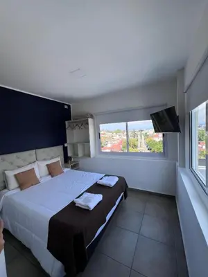 a bedroom with a large bed and a large window at Astoria Hotel in Villa Carlos Paz