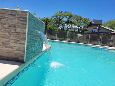 a water fountain in a swimming pool at Cabaña premium! in Villa Anizacate