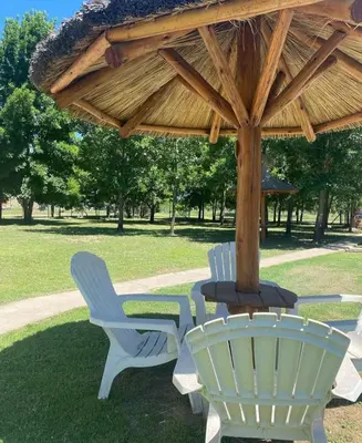 a table and chairs under a wooden umbrella at Cabaña premium! in Villa Anizacate