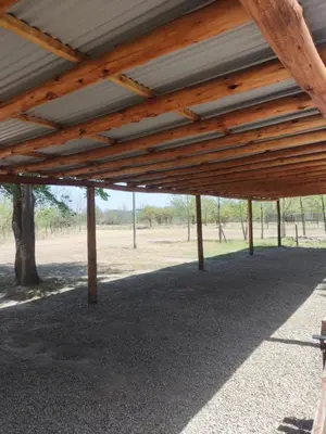 a wooden pavilion with a view of a field at Cabaña premium! in Villa Anizacate