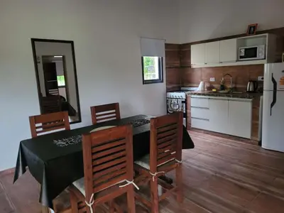 a kitchen with a table and chairs and a refrigerator at Cabaña premium! in Villa Anizacate