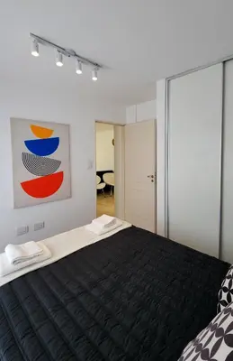 a bedroom with a black bed and a painting on the wall at Pent House Nueva Córdoba in Cordoba