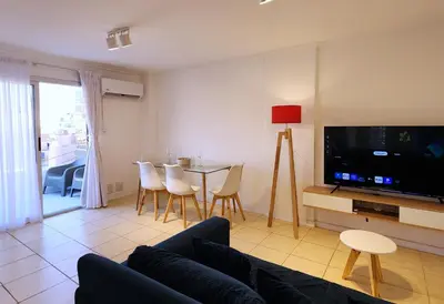 a living room with a couch and a tv and a table at Pent House Nueva Córdoba in Cordoba