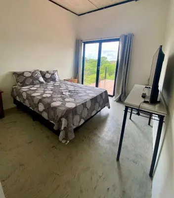 a bedroom with a bed and a desk with a television at Monte Adentro in Dique Nivelador