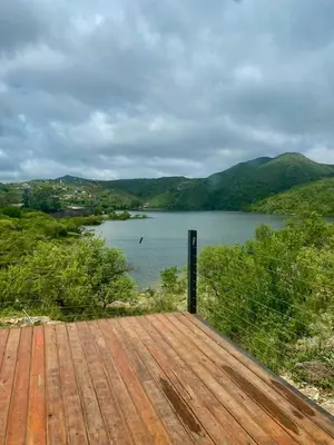 a wooden deck with a view of a lake at Monte Adentro in Dique Nivelador
