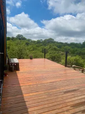 a wooden deck with a view of a forest at Monte Adentro in Dique Nivelador