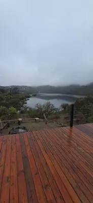 a wooden deck with a view of a lake at Monte Adentro in Dique Nivelador