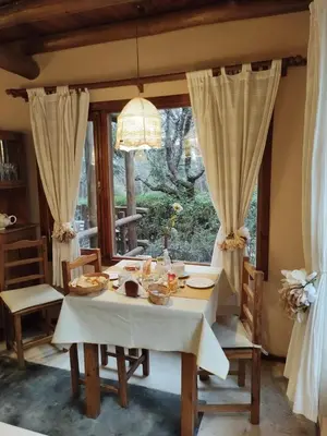 a dining room with a table and chairs and a window at Posada La Lucía in Villa General Belgrano