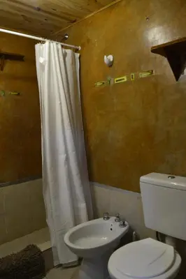 a bathroom with a toilet and a shower curtain at Posada La Lucía in Villa General Belgrano