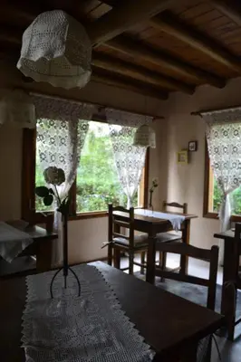 a dining room with a table and chairs and windows at Posada La Lucía in Villa General Belgrano