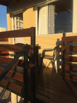 a chair sitting on the deck of a house at Depto temporario Carlos paz in Villa Carlos Paz