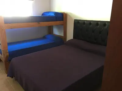 a bedroom with two bunk beds and a blue bed at Depto temporario Carlos paz in Villa Carlos Paz