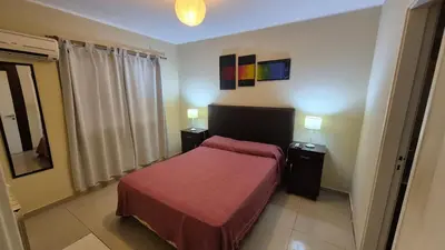 a bedroom with a bed with a red blanket at Departamento pleno centro Carlos Paz con pileta in Villa Carlos Paz