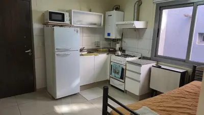 a kitchen with a white refrigerator and a microwave at Departamento pleno centro Carlos Paz con pileta in Villa Carlos Paz