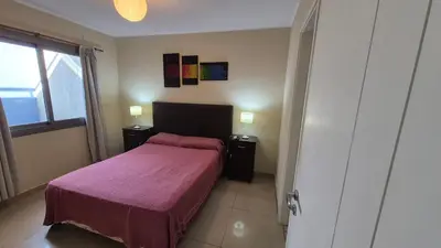 a bedroom with a bed with a purple blanket at Departamento pleno centro Carlos Paz con pileta in Villa Carlos Paz