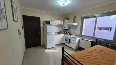 a small kitchen with a white refrigerator and a window at Departamento pleno centro Carlos Paz con pileta in Villa Carlos Paz