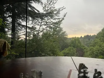 a person is looking out of a window at a table at Casa Familiar in La Cumbrecita