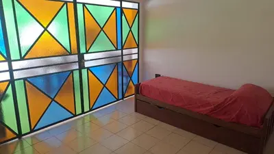 a room with a stained glass wall with a bed at Bosquesito in Mina Clavero
