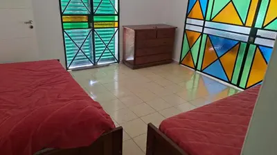 a room with two beds and stained glass windows at Bosquesito in Mina Clavero