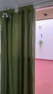 a green curtain in a room with a window at Grivia in Cordoba