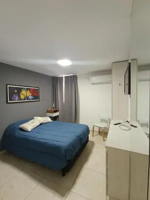 a bedroom with a blue bed and a desk at Departamento moderno y luminoso in Cordoba