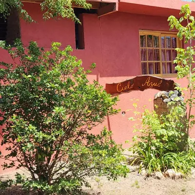 a pink building with a sign in front of it at Cielo Azul in Santa Rosa de Calamuchita