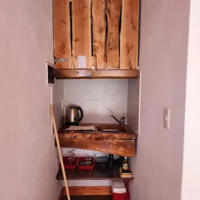 a small kitchen with wooden cabinets and a sink at Cielo Azul in Santa Rosa de Calamuchita