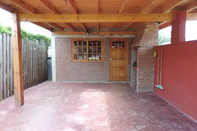 a patio with a wooden roof and a door at Cielo Azul in Santa Rosa de Calamuchita