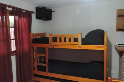a bunk bed with a tv on the wall at Cielo Azul in Santa Rosa de Calamuchita