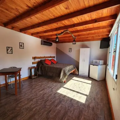 a bedroom with a bed and a desk in a room at Cielo Azul in Santa Rosa de Calamuchita