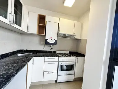 a kitchen with white cabinets and a stove top oven at Victoria Tower Category Department in Villa Carlos Paz