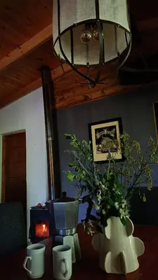 a room with a table with two vases and a lamp at Cabaña El Bordoneo in Villa Yacanto