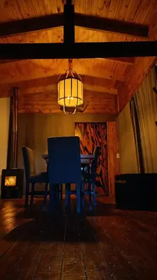 a dining room with a table and chairs and a chandelier at Cabaña El Bordoneo in Villa Yacanto