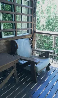 a bench sitting on a porch next to a window at Cabaña El Bordoneo in Villa Yacanto