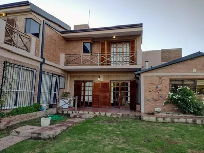 a brick house with a porch and a balcony at Rincón Serrano in Villa Carlos Paz