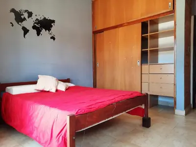 a bedroom with a large red bed and a cabinet at Rincón Serrano in Villa Carlos Paz