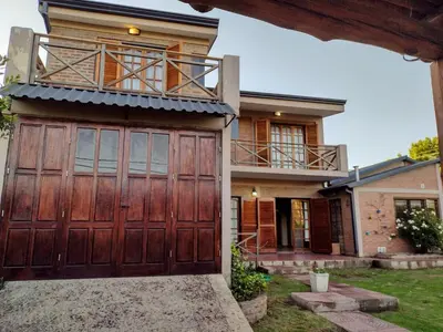 a house with a large wooden garage door at Rincón Serrano in Villa Carlos Paz