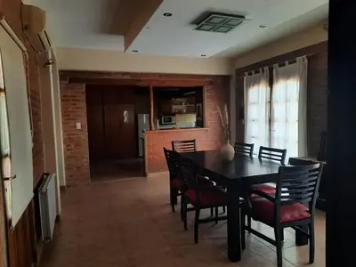 a dining room with a black table and chairs at Rincón Serrano in Villa Carlos Paz