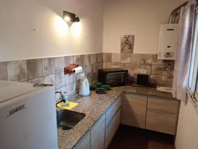 a kitchen with a sink and a microwave at Playa Hostel in Santa Rosa de Calamuchita