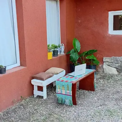 a laptop computer sitting on a table next to a building at Playa Hostel in Santa Rosa de Calamuchita