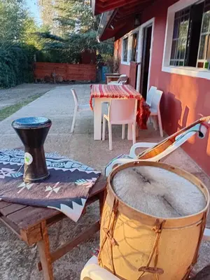 a table with a drum and a table with a tableablish at Playa Hostel in Santa Rosa de Calamuchita