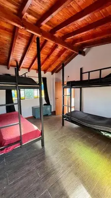 two bunk beds in a room with a wooden ceiling at Playa Hostel in Santa Rosa de Calamuchita